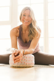 Die lächelnde Yoga-Lehrerin Andrea Kurth, die Entspannungstechniken auf einem Meditationskissen praktiziert