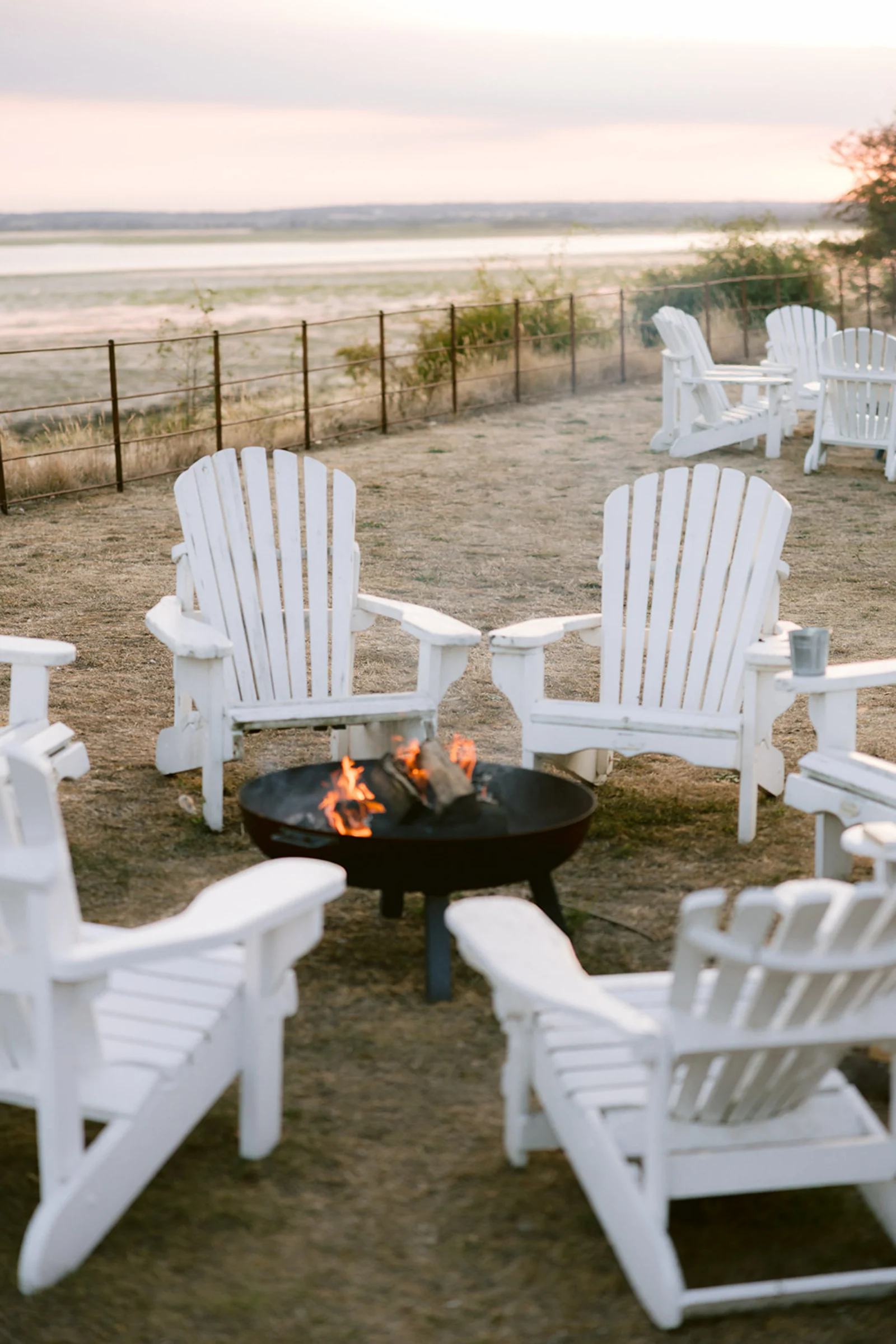 White deck chairs surround a firepit at sunset on Osea Island.