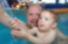 Father and a toddler swimming