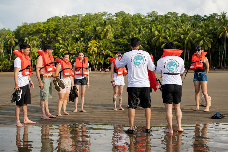Foto de clientes en la playa recibiendo información sobre seguridad.