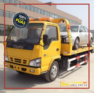 Tow truck near me sedang memuatkan kereta ke platform lori penunda di Kuala Lumpur.