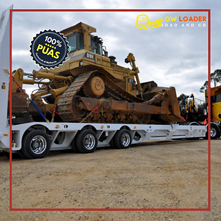 Low loader truck Malaysia mengangkut mesin industri berat dengan selamat.