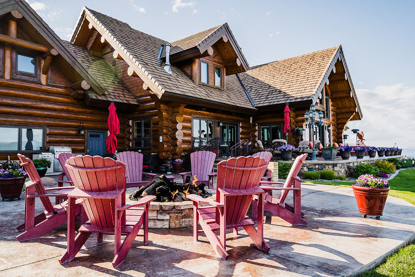 The fire pit circle and red Adirondack chairs beside the lodge