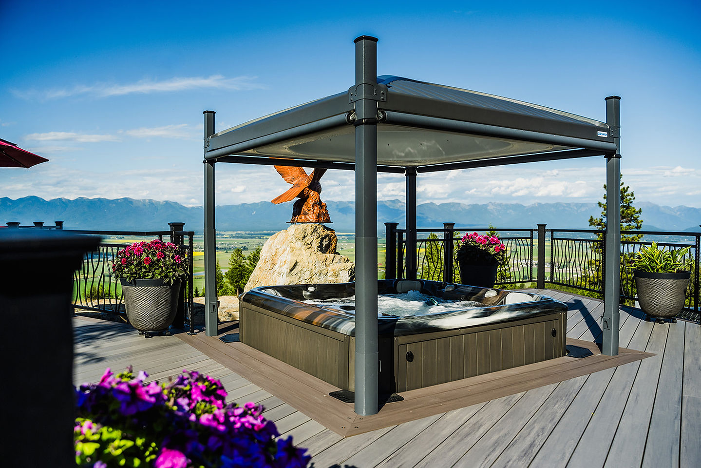 A private hot tub pavilion with an eagle sculpture and the lake beyond