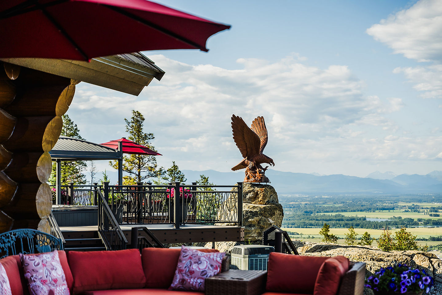 An eagle sculpture above an outdoor sofa on the deck