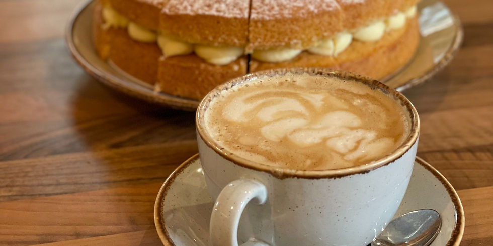 Cup of coffee with a homemade cake behind