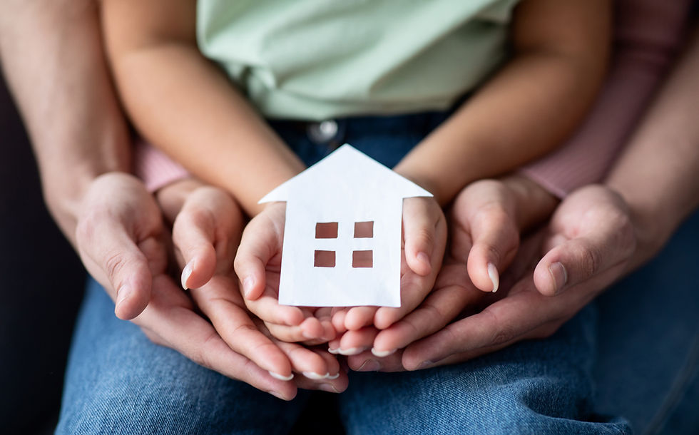 Man, woman and little child holding cutout paper house figure in hands, conceptual image f