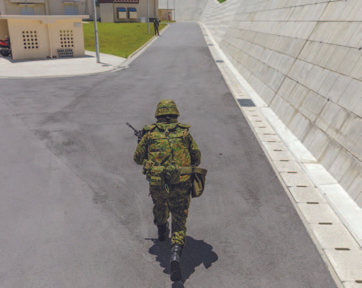 A Japanese soldier during a training exercise on the island of Okinawa on May 23, 2025. The country’s postwar Constitution is under scrutiny as Japan rebuilds its military, spooked by a rising China and other potential threats. (Ko Sasaki/The New York Times)