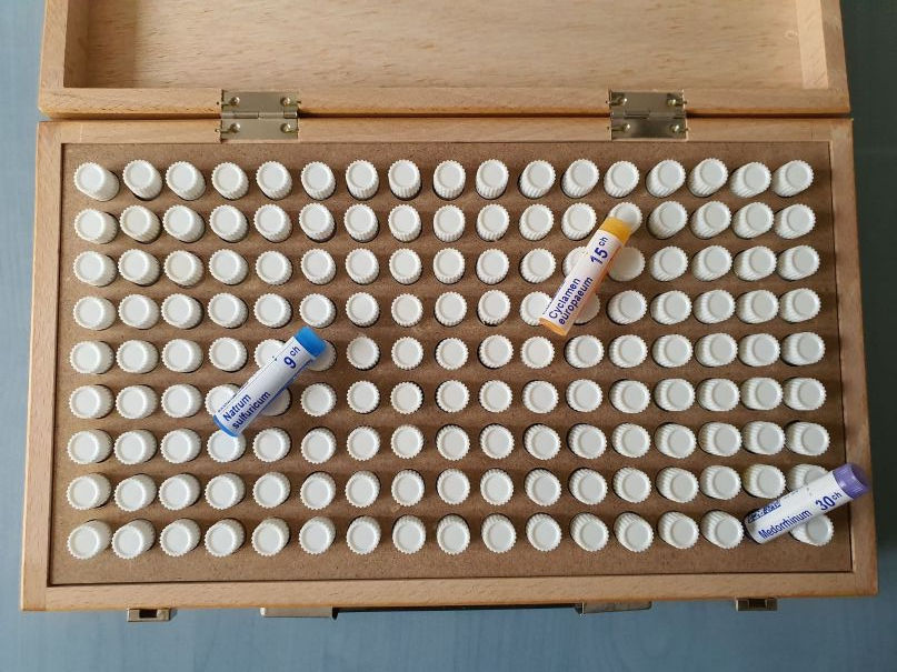Boîte test homéopathique pour la recherche en homéopathie. Elle est en bois.