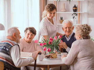 un grupo de personas adultas en una mesa tomando una merienda 