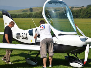 Pilot conducting a preflight inspection of a small aircraft before departure.