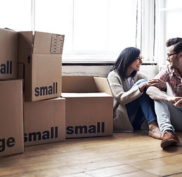 A relaxed couple sitting on the floor of their new home, surrounded by unpacked boxes and packing materials. Their expressions of happiness and relief reflect the excitement of starting fresh in a new space. This image captures the emotional journey of moving, highlighting the support provided by ASAP Movers in making transitions enjoyable and stress-free.