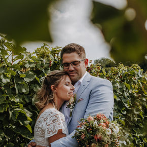 Brautpaar hält sich im Arm in den Weinbergen – emotionale Hochzeitsfotografie in natürlicher Umgebung in Rheinhessen