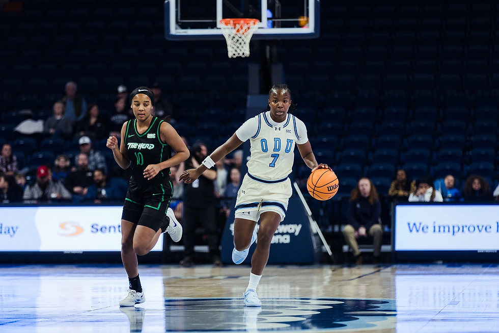 Thompson brings the ball down the court while holding off defender.