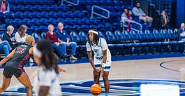 Basketball player dribbling the ball down court.