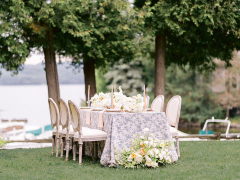 a beautiful flowery wedding table set by the lake