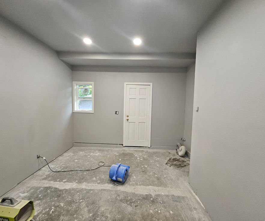 Interior view of a painted garage with concrete floor prepared for tile and epoxy.