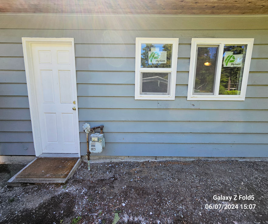Exterior view of a garage with new windows and matching wood siding.