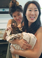 two women holding and petting a baby wallaby in maryland