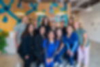 The Sola Kids Dental & Orthodontics pediatric dental team smiling in the reception area, showcasing a welcoming and supportive environment for children and families.