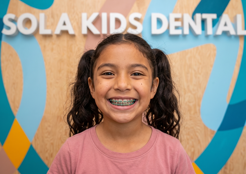 Happy child showing colorful braces at Sola Kids Dental orthodontic and pediatric dental clinic