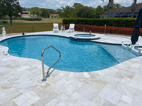 Custom concrete swimming pool with raised spa and waterfall built by Trinity Pools in Citrus County Florida