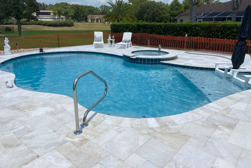 Custom pool with handrail and integrated spa by Trinity Pools in Citrus County