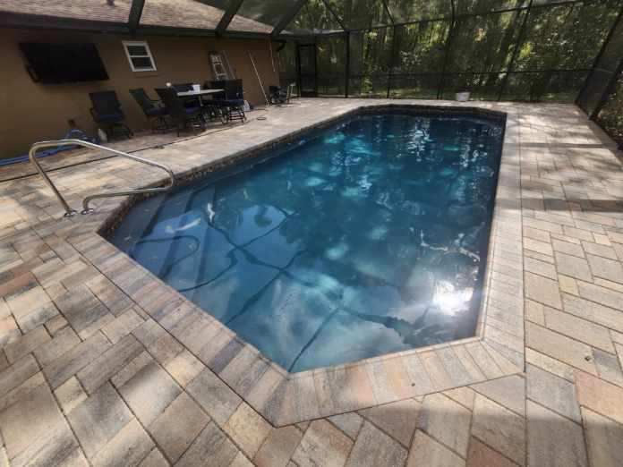 Compact geometric inground pool with light paver deck by Trinity Pools in Citrus County