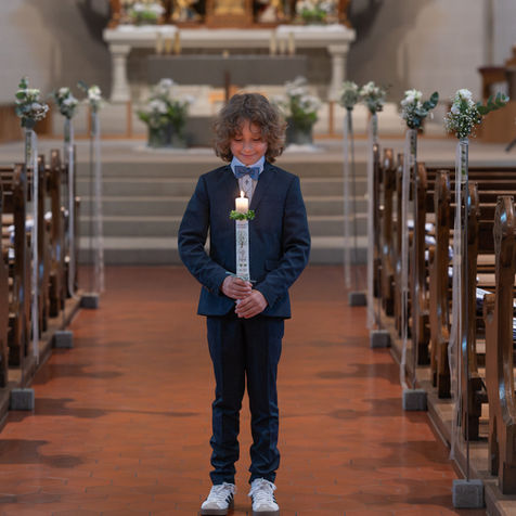 Erstkommunion Junge in Anzug Porträt in Kirche mit natürlichem Licht cineastische Fotografie