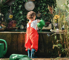 familienshooting portrait von kleinkind mädchen im garten spielend 