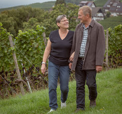 Paar verliebt beim spazierengehen in den eigenen Reben. Vertrauter Blick. 
