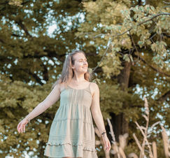 Junge Frau in Abendstimmung zwischen Weinreben, Portraitaufnahme bei Golden Hour mit warmem Licht