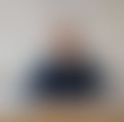 Smiling secondary mathematics teacher in front of a whiteboard with equations