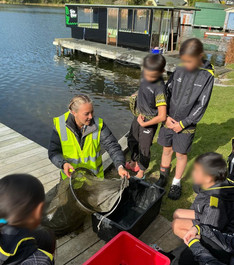 Students and an educator working together at a lake jetty during a Te Arawa Catfish Killas field experience focused on freshwater ecology.
