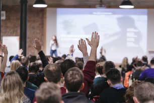 Audience raising hands during a public consultation meeting, representing community engagement in the Draft NZ Curriculum 2026 consultation process.