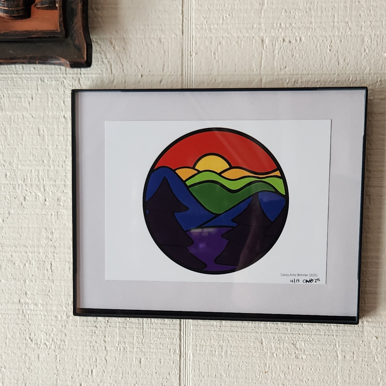 Gay by Nature print - landscape drawing with rainbow parts - signed, numbered, and framed on a wall.