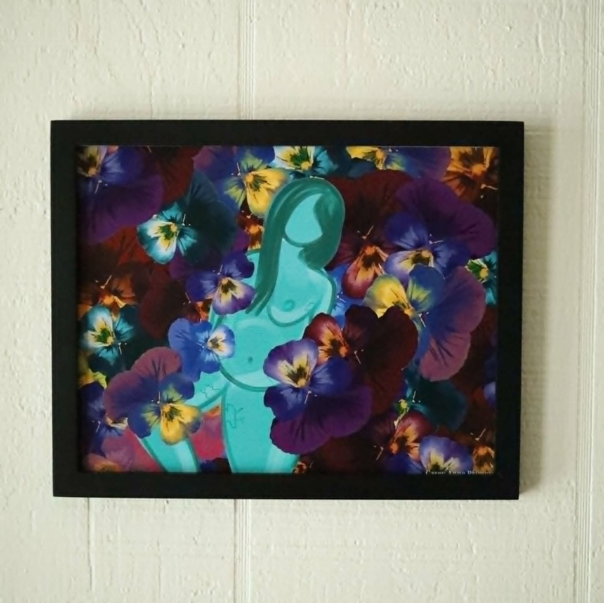 Framed print of drawing "Embracing" a nude teal body with stretch marks and exposed breast & belly in a bed of flowers.