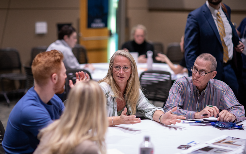 Attendees seated in the MREIC Deal Room listen as a real estate investor presents a live opportunity for discussion, feedback, and potential partnership.