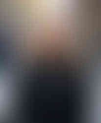 AI-generated image of a woman in a black turtleneck standing on a city street. While the setting looks realistic, the face has an artificial polish and subtle asymmetries.