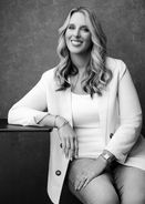 Black and white branding portrait of a healthcare provider seated in a white blazer.