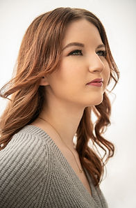 Young woman with red hair and natural makeup in profile pose during a luxury beauty portrait session in The Villages Florida