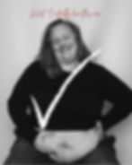 Amanda smiles while confidently showing her belly in a black-and-white self-portrait, with a white check mark and the words “Wait… I actually love this one.”