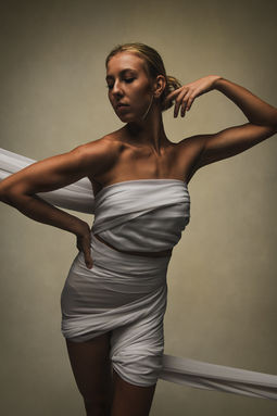 Fashion inspired portrait of a woman in a sculpted silver dress with strong posing in The Villages, FL.