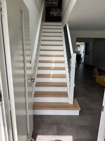 Modern Hybrid SPC stair case with white risers. Accentuates the natural colour of each tread. Paired with darker tones like this Andesite Hybrid Tile, allows the stairs and flooring to complement each other.