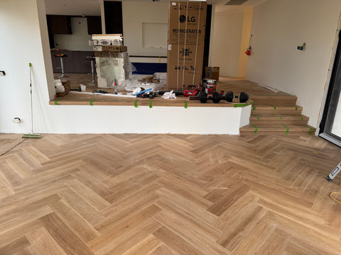 Iconic timeless herringbone engineered parquet, direct stick on self-levelling compound sealed with moisture sealer. Featuring a 4 meter wide void-edge and wrap around step at the end.