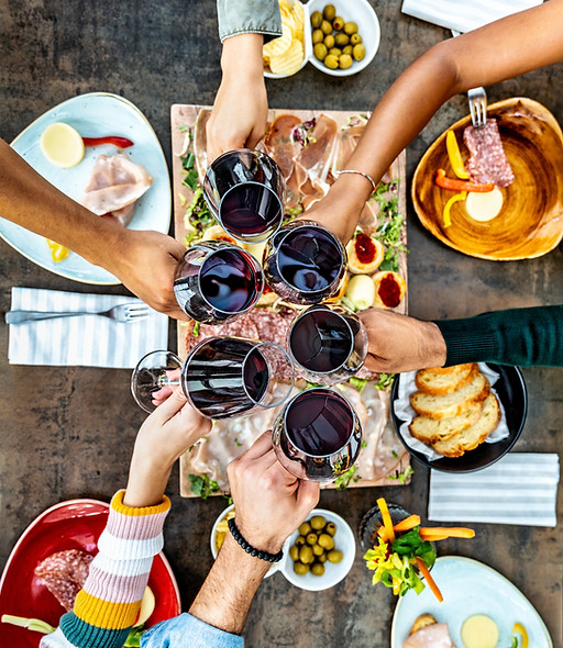 Friends cheering red wine glasses on tab