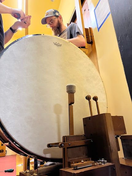 Workers adjust the restored 1925 Wurlitzer bass drum before installation.