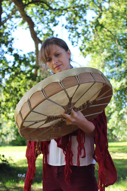Woman beating a shamanic drum in a drum circle | The Wild Edges | Shamanic Healing | Reiki | Nature connection | Llyn Peninsula | North Wales