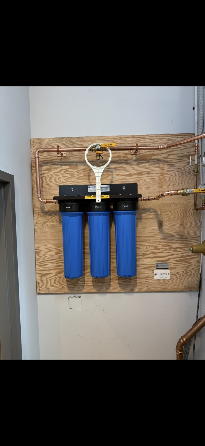 Boyle three-stage whole-home water filtration installation with blue housings and copper connections