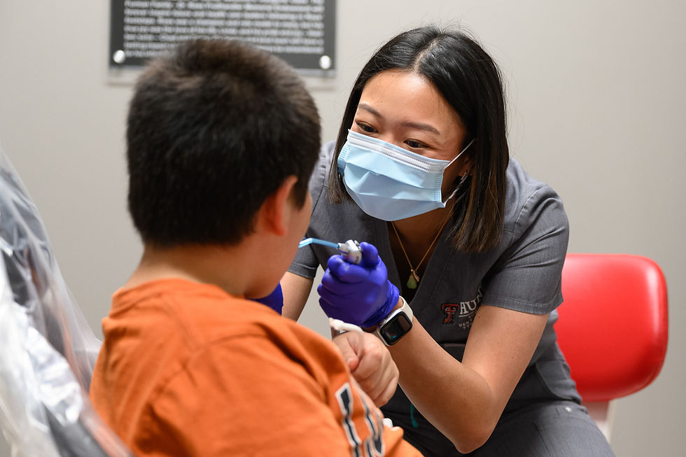 Kelly Yang Works on a young patient's teeth.